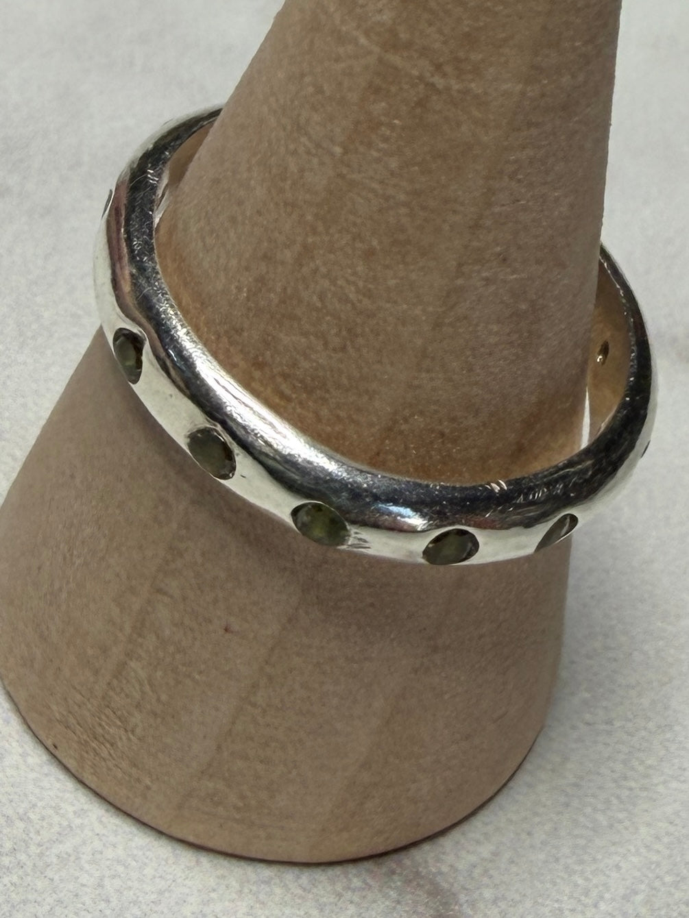 Handmade sterling silver ring with green flush set CZ stones. Size O