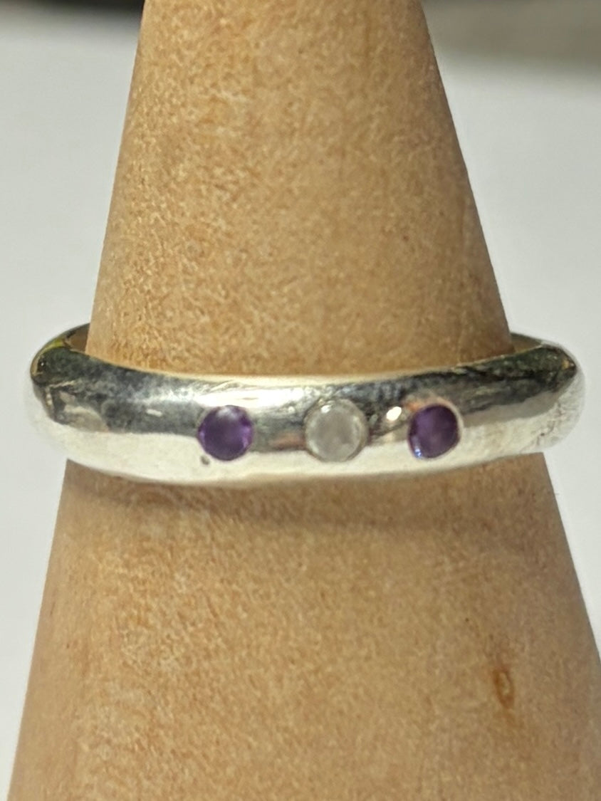 Handmade sterling silver ring with flush set stones. Purple stones and one clear. Size P