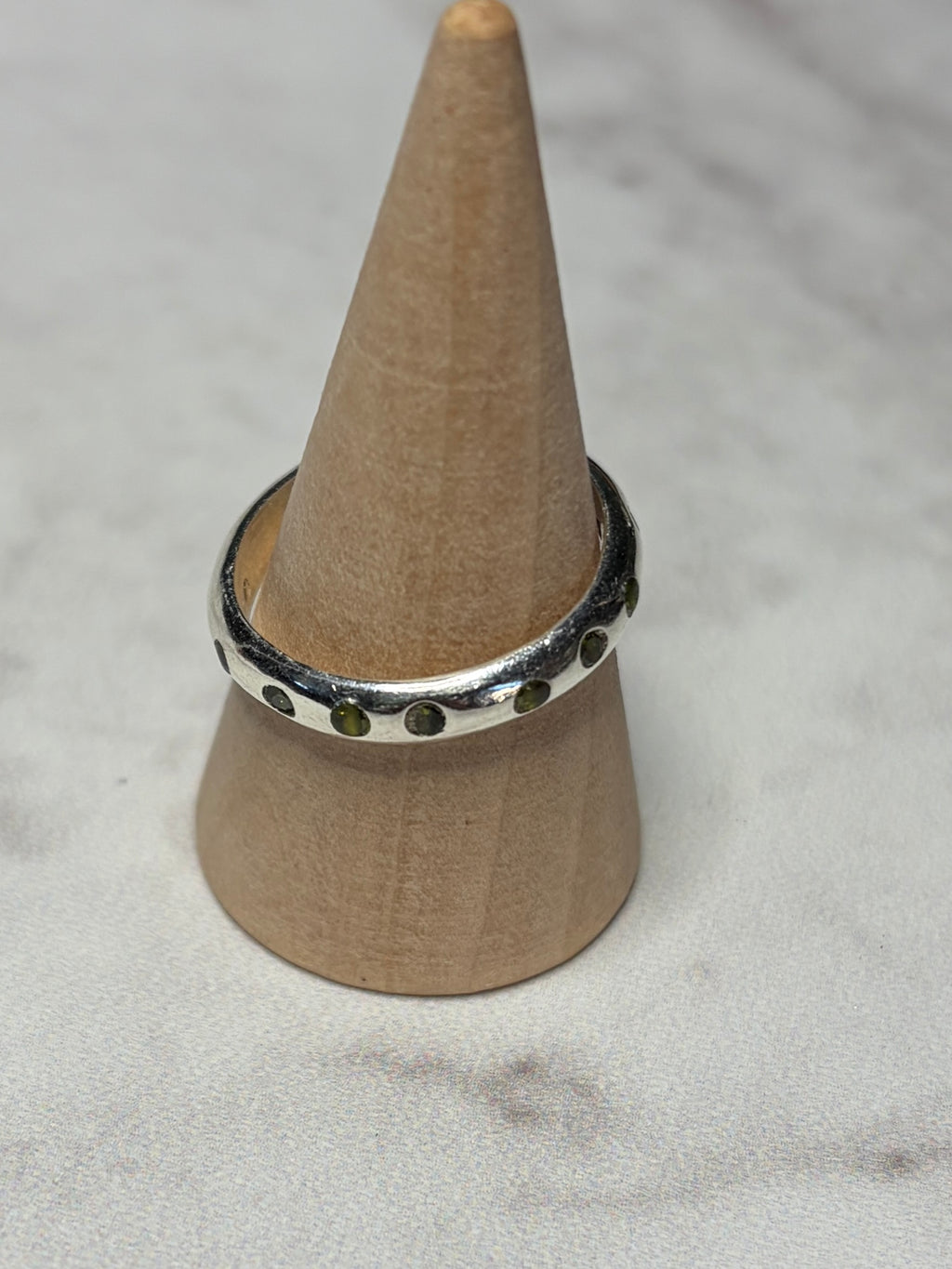 Handmade sterling silver ring with green flush set CZ stones. Size O