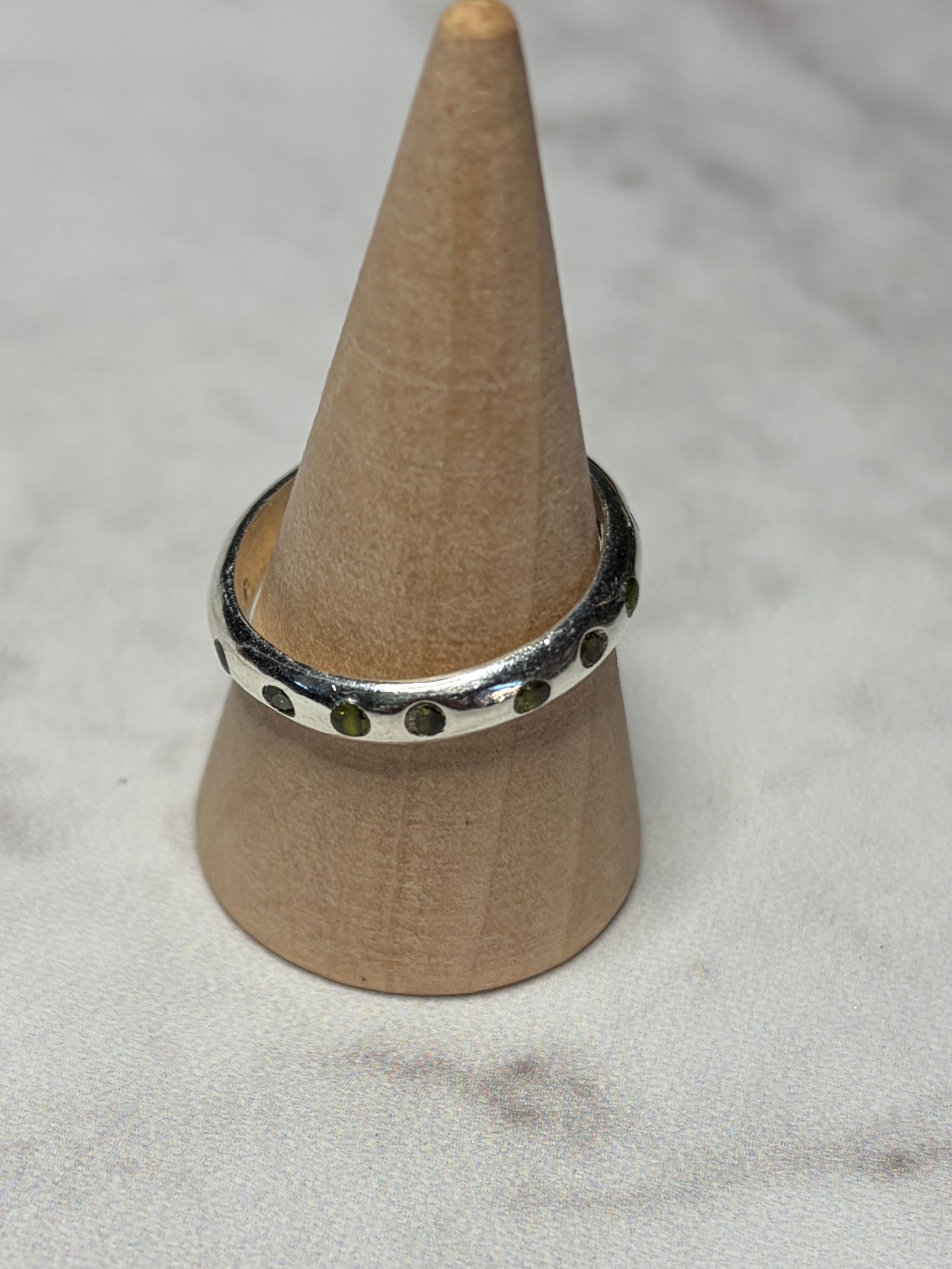 Handmade sterling silver ring with green flush set CZ stones. Size O
