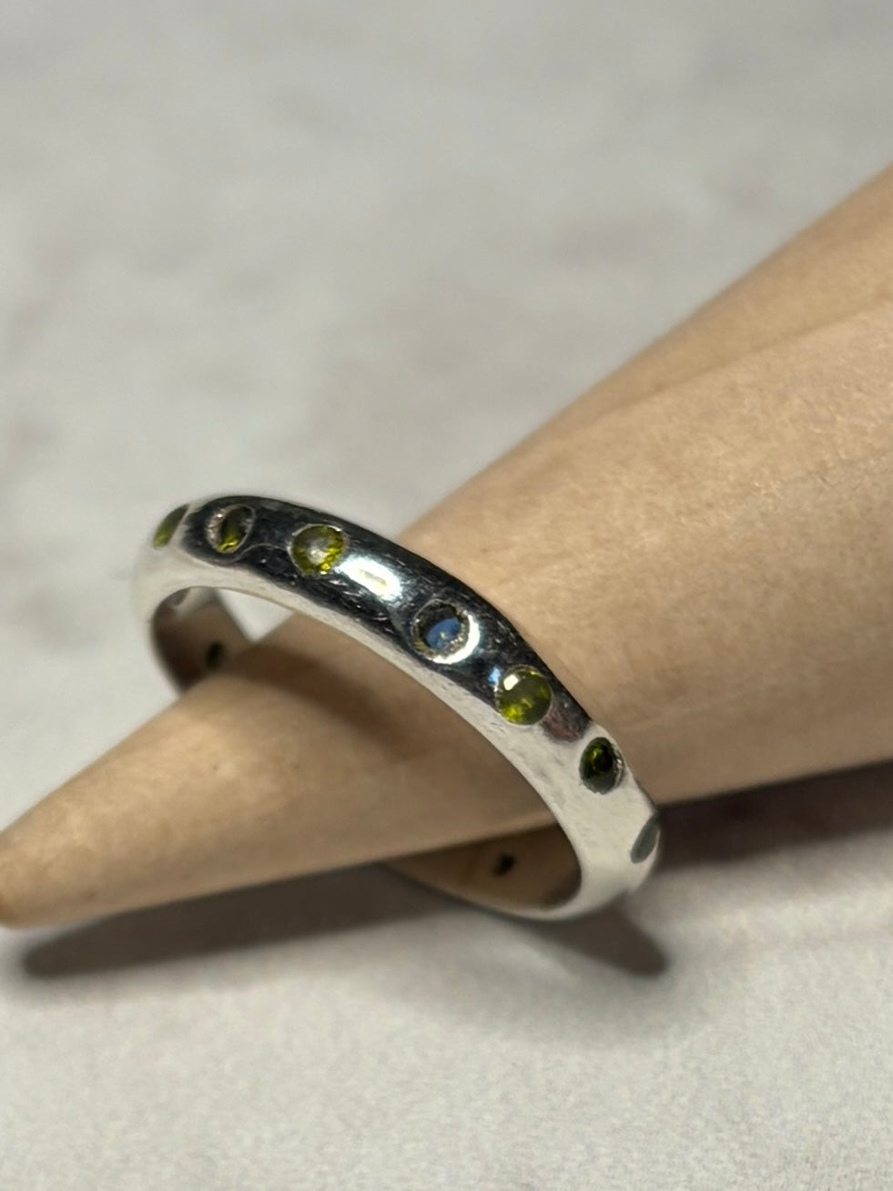 Handmade sterling silver ring with green flush set CZ stones. Size O