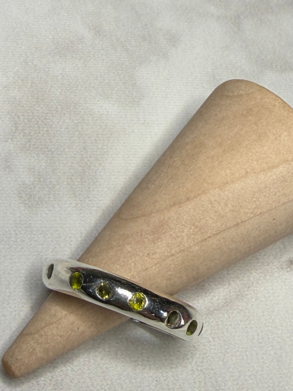 Handmade sterling silver ring with green flush set CZ stones. Size O